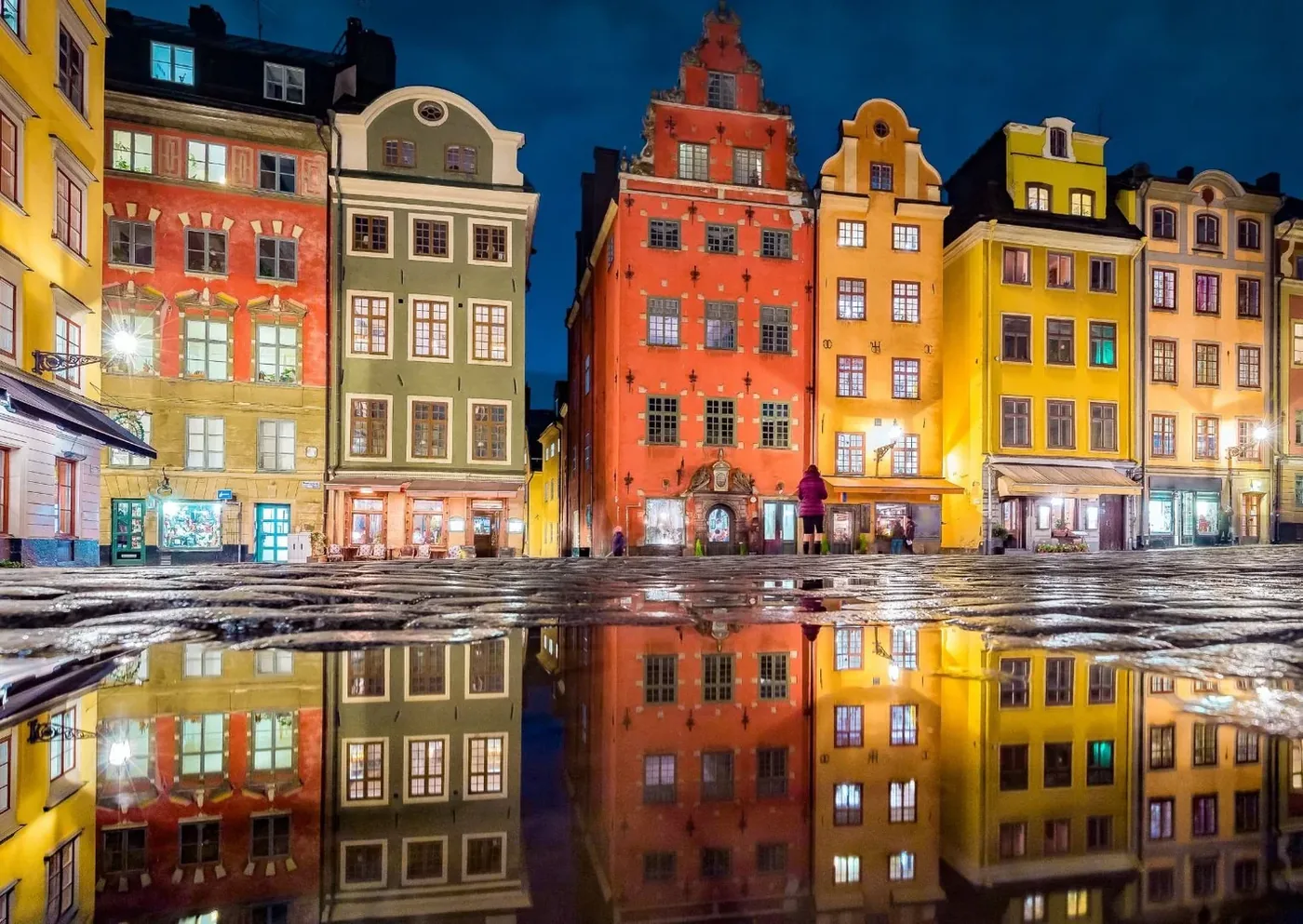 Colourful buildings on Stortorget in Stockholm’s Old Town, reflected in the wet square